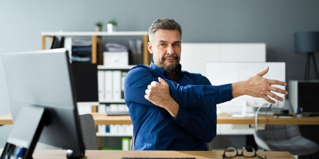 Deskercise helpt tegen werkstress, dit is een foto van een stretch oefeningen achter je bureau